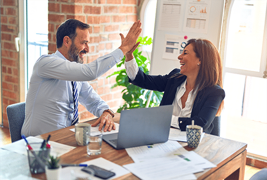 Man and a woman giving a high-five in an office space