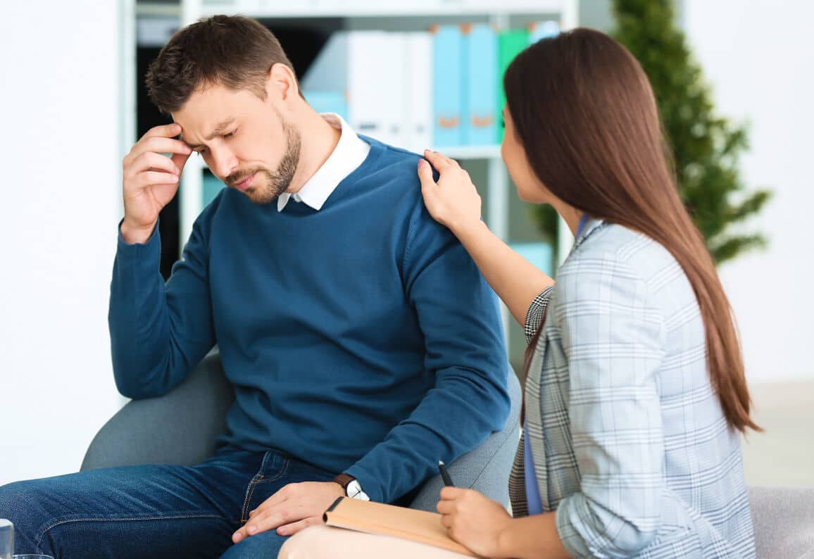 Woman consoling a man in an office environment