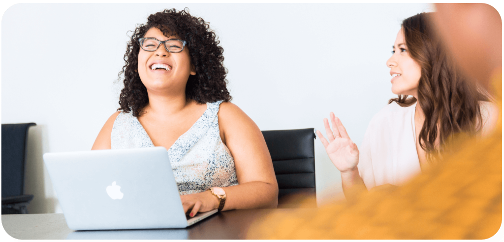 Woman laughing at a laptop